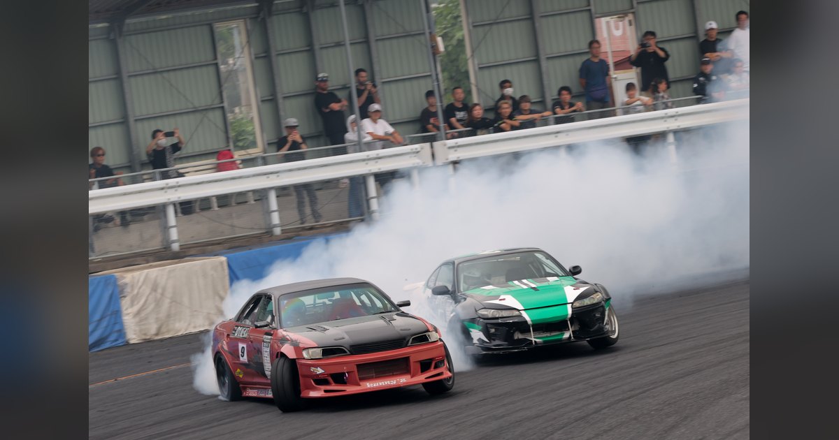 Car #9, a red JZX90 Mark II, leads a green and black S15 through smoke in a tandem battle at Mobara Twin Circuit during D1 NEXT Central Series 2026 Rd.3