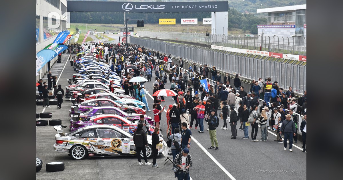 Official D1 Grand Prix photo of fans walking the pit lane beside the lined-up competition cars during a D1 pit walk