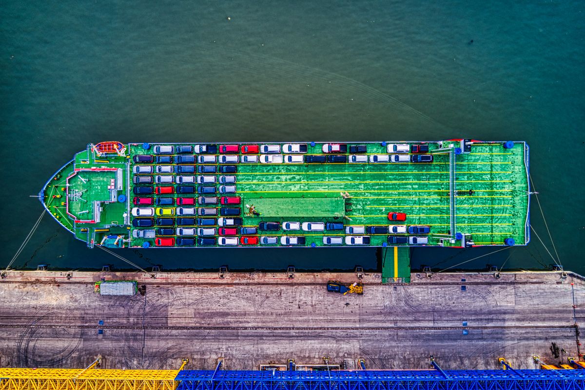 Aerial view of a vehicle carrier ship loaded with cars at a dock