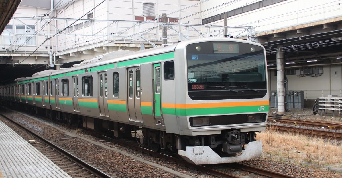 A JR East commuter train in the green-and-orange livery used on the Utsunomiya Line, standing at a platform